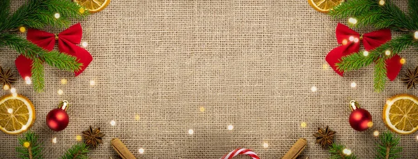 Buon Natale e Buone Feste biglietto di auguri, cornice, banner. Capodanno. Noel. Natale rosso, ornamenti verdi e gialli e regalo su sfondo lino vista dall'alto. Tema delle vacanze natalizie invernali. — Foto Stock