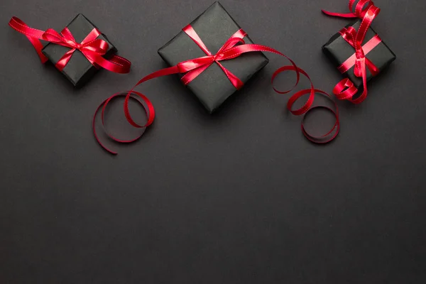 Świąteczna dekoracja. czerwone prezenty świąteczne, ozdoby na czarnym tle. Święta zimowe prezentują koncepcję. Wesołych Świąt i Wesołych Świąt kartka okolicznościowa, ramka, baner — Zdjęcie stockowe