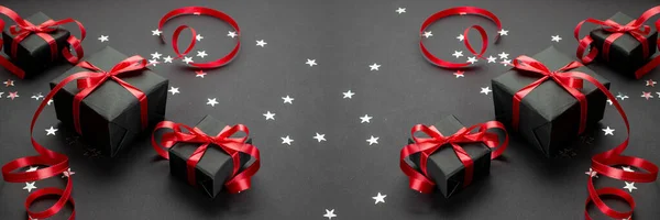 Nouvel an fond. Cadeaux de Noël avec ruban rouge sur fond noir. Cadeau de Noël. Concept vacances d'hiver. Joyeux Noël et Joyeuses Fêtes carte de voeux, cadre, bannière — Photo