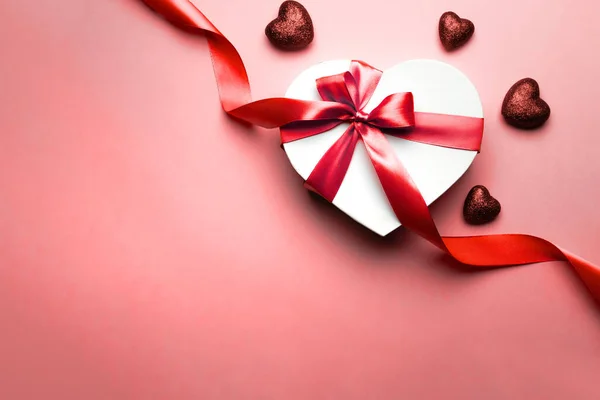 Tarjeta de San Valentín. Caja de regalo en forma de corazón con cinta roja aislada en rojo. Plantilla de mensaje romántico con espacio de copia . — Foto de Stock