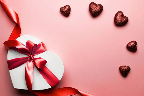 Banner del día de San Valentín. Caja de regalo en forma de corazón con cinta roja aislada en rojo. Plantilla de mensaje romántico con espacio de copia . —  Fotos de Stock