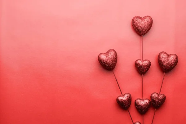 Valentin napi rutin. Piros kis szívek pálcikákon, piros háttérrel. Romantikus szétszórt szív textúra. Szerelem. — Stock Fotó