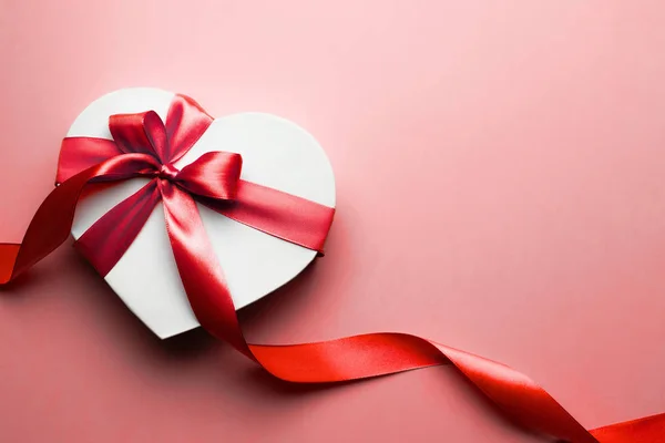 Caixa em forma de coração com fita vermelha isolada no fundo vermelho. Conceito de Valentim, aniversário, dia das mães e aniversário, copyspace, topview . — Fotografia de Stock