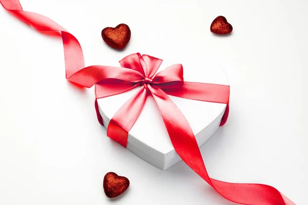 Fondo del día de San Valentín. Caja de regalo blanca con arco y corazón de cinta roja, plantilla de foto, fondo. Vista superior . — Foto de Stock