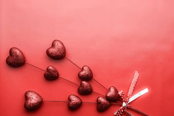 Patrón de San Valentín. Pequeños corazones rojos en palos sobre fondo rojo. Textura romántica de corazones dispersos. Amor. . — Foto de Stock