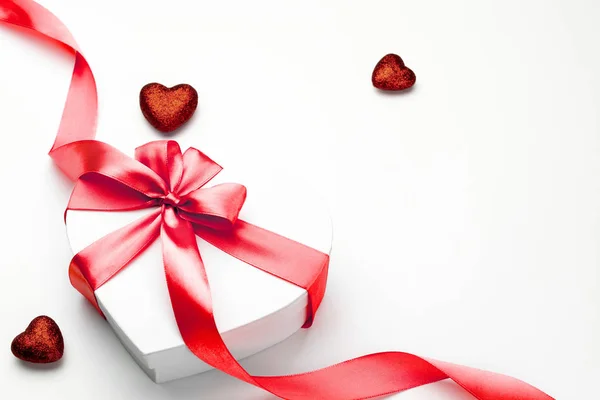 Tarjeta de San Valentín. Caja de regalo en forma de corazón con cinta roja aislada en blanco. Plantilla de mensaje romántico con espacio de copia . —  Fotos de Stock