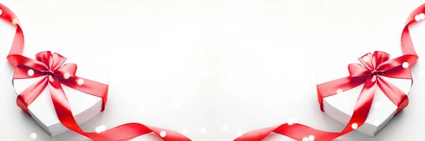 День святого Валентина фон. Белая подарочная коробка с бантом и красной лентой сердца, фото искушение, фон. Вид сверху . — стоковое фото