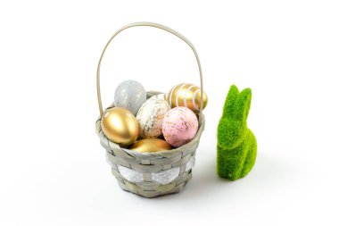Easter egg hunt. Easter composition: golden shine decorated eggs in basket with green bunny. Greeting card trendy design. for you poster or flyer.