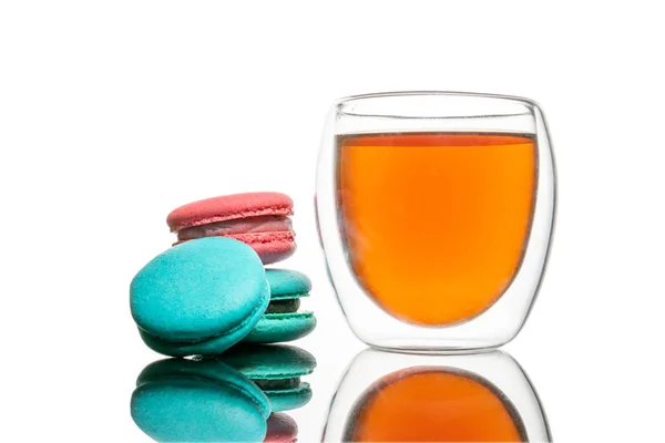 Skleněný šálek černého čaje, makarónové sušenky Izolované na bílém. Barevné a sladké francouzské makróny pozadí — Stock fotografie