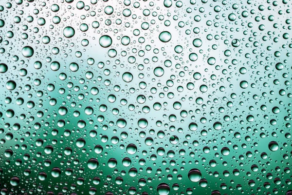 窓ガラスに水が落ちる。雨の質感やウェットパターンの背景. — ストック写真