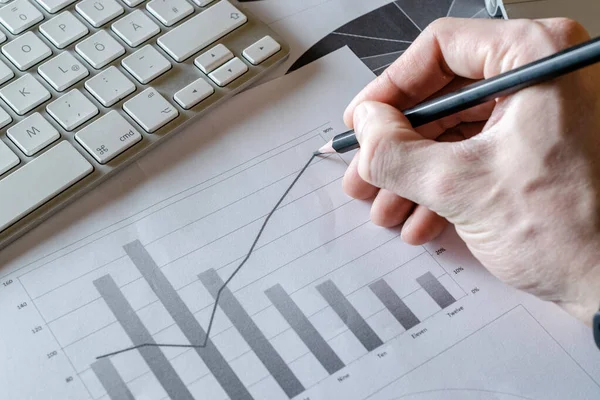 Reviewing paperwork. Charts graphs diagrams on table. Analytics finance background. Concept image of data gathering and statistical working.