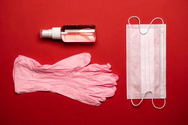 Medical gloves surgical mask, sanitizer gel - Virus protection equipment on red background. China pathogen respiratory coronavirus 2019-ncov flu outbreak medical concept