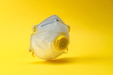 Coronavirus salgını salgını koruması. Sarı üzerine hijyenik tıbbi güvenlik maskesi. Tehlikeli grip vakaları, salgın hastalık riski kavramı olarak kabul edilir.