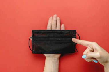 Koruyucu tıbbi maske, kırmızı arka planda laboratuvar eldivenleri. Coronavirus hastalığı ekipmanları. COVID-19 'a karşı önleyici önlemler. Cerrahi ve tıbbi muayene için profesyonel güvenlik ve hijyen.