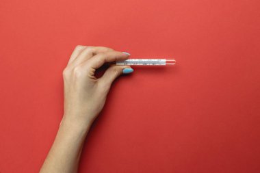 Tıbbi arka plan kırmızı. Kadın elleri ısıyı kontrol etmek için termometre kullanır. Virüs koruma ekipmanları, önleyici önlemler. Tehlikeli Asya Ncov Corona virüsü.