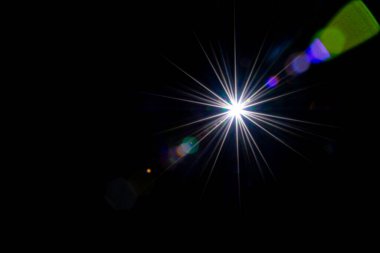 Mercek güneş ışığı soyut arkaplan. Güneş ışığı yıldız lekesi parlıyor. Güneş ışığının siyaha yansımasını sağlıyor. Fotoğrafların üzerine kaplama ya da ekran filtresi olarak eklemek kolay