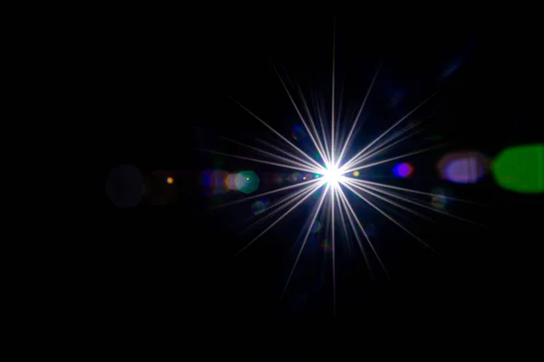 플레어 선광을 내리 세요. 태양 광선의 번쩍 임 효과 또는 별의 점 광은 검은 배경에 밝게 빛난다. 둥그스름하고 육각형인 무지개 할로 — 스톡 사진