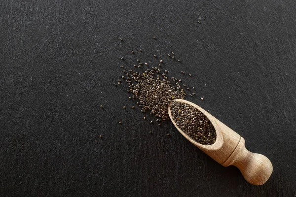 Superfood lino chia fondo saludable. Pila de semillas negras en cuchara de madera para la comida. Vitamina snack desayuno, dieta y concepto de alimentación saludable . — Foto de Stock