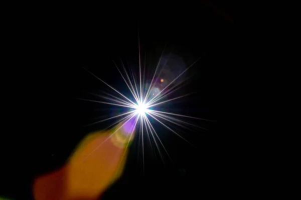 Fondo abstracto de luz solar. Rayo de efecto flash en negro. El punto de estrella o el sol brillan con luz brillante en la lente. Luces Bokeh y reflejo óptico de fugas . —  Fotos de Stock