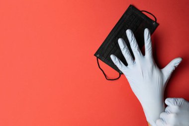 Hasta maske, eldivenler kırmızıya tutunuyor. El solunum cihazı, antibakteriyel dezenfektan jel, laboratuvar eldivenleri, tıbbi arka plan. Coronavirusa karşı koruyucu önlemler. Profesyonel hijyen..