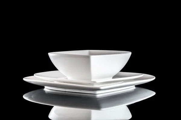 흰 자기 접시가 테이블 위에 있다. 저녁 식사 배경. 검은 배경에 빈 둥근 고립. 레스토랑 주방 의제 일성 개념. — 스톡 사진