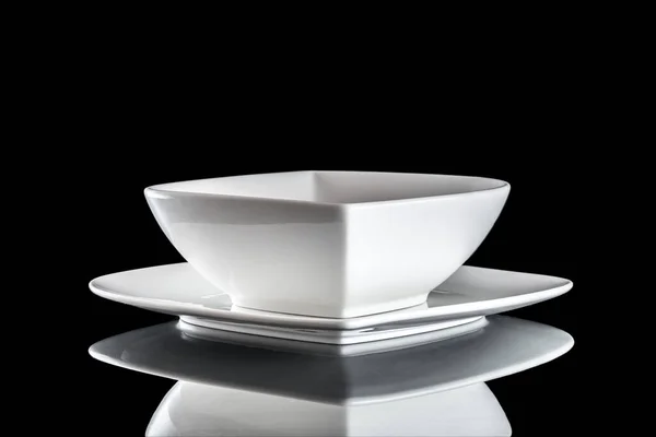 Посуд ізольовано на чорному. Квадратна біла порожня тарілка для вечері на темному фоні. Чисте коло порцеляновий посуд. Сніданок посуд . — стокове фото