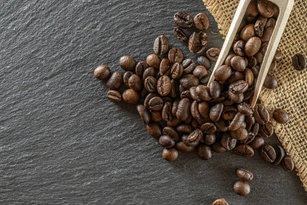Cafe coffee background. Espresso beans for food, drink caffeine breakfast on black. Brown roasted coffee seeds isolated for energy mocha, cappuccino ingredient. Copy space, top view.