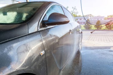 Araba yıkama servisinde su temizleyici araba. Sabundan araba yıkama, daha temiz bir istasyonda köpük. Basınç ağdasına dikkat