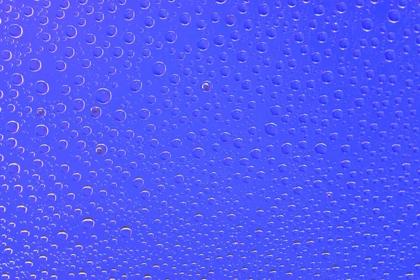 Gotas de agua textura fondo. Lluvia sobre vidrio de ventana. Patrón de lluvia húmeda . — Foto de Stock