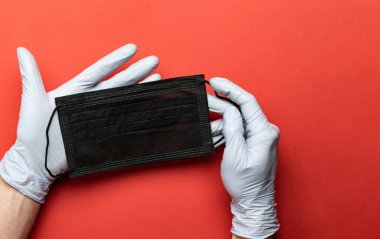 Sağlık eldivenli kırmızı cerrahi arka plan, koruyucu tıbbi maske. Antiseptik el antibakteriyel dezenfektan laboratuvar eldivenleri kullanıyor. Corona virüsü önleme, hijyen, koronavirüs yaymayı durdurmak için..
