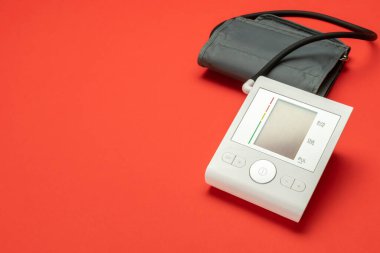 Tıbbi gereçler yaşam. Doktor ve hasta için hipertansiyon ölçer ile kalp hipertansiyonu kontrolü. Kan basıncı için tıbbi test monitörü kırmızı arka planda izole edildi. Hastane tanı teknolojisi.