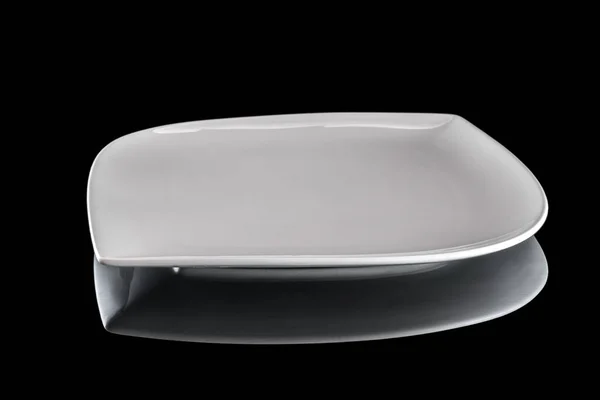 Белая круглая тарелка для еды на темном фоне. Пустая посуда на ужин изолирована от черного. Ресторан кухня минималистская концепция . — стоковое фото