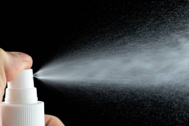 Aerosol sıçrama arkaplanı. Siyah üzerine izole edilmiş parfüm şişesinden sıvı su spreyi..