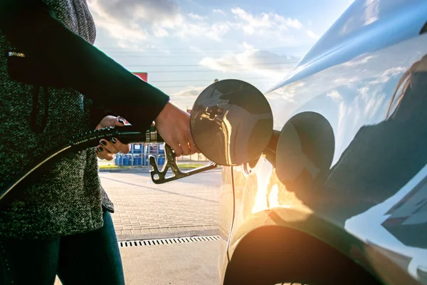 자동차 기름을 채우고 있다. 가솔린 주유소의 연료 펌프 노즐 탱크. 연료를 재주입하는 총의 검은 손잡이. — 스톡 사진