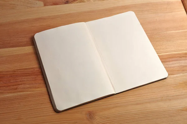Open boek met blanke pagina met een pen geïsoleerd op hout achtergrond. Vooraanzicht. Papier textuur. Mock up — Stockfoto