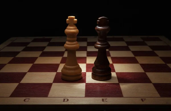 Ajedrez de madera. Rey blanco y negro en tablero de ajedrez . — Foto de Stock