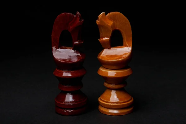 Satranç. Siyah arka plan üzerine siyah ve beyaz şövalyeler. Satranç figürleri kümesi.