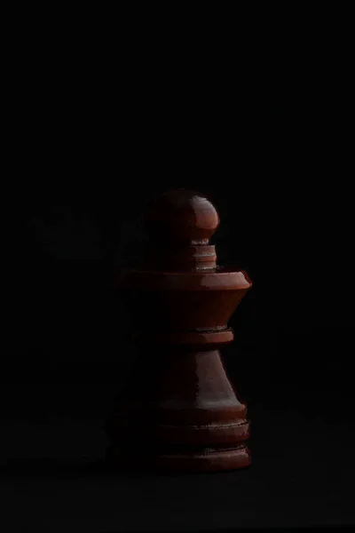 Шахматы. Чёрная пешка на чёрном фоне . — стоковое фото