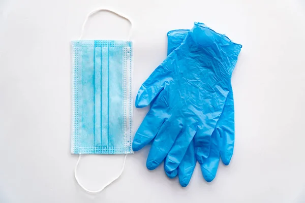 COVID19 koronavirüs koruyucu denekler. Tek kullanımlık plastik eldivenler ve beyaz bir arka planda maske. Coronavirus koruması.