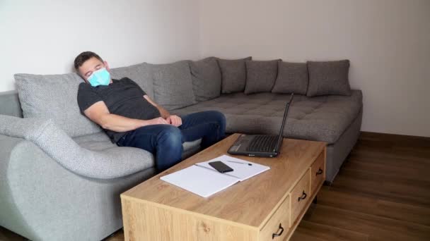Empresario en máscara médica está cansado del trabajo y duerme en el lugar de trabajo. Cuarentena coronavirus COVID19 trabajo a distancia . — Vídeos de Stock