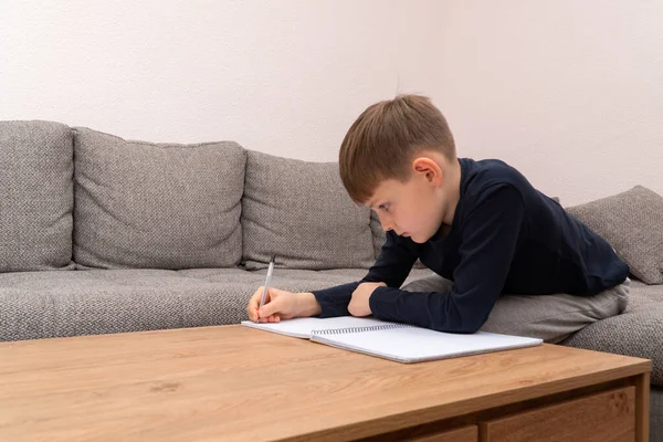 Coronavirus salgını. Evde karantinaya alınmış bir çocuk. Uzaktan eğitim ve öğrenme. Kendini izole et, ev karantinası. Dünya Krizi COVID-19. Evde uzaklık öğrenimi