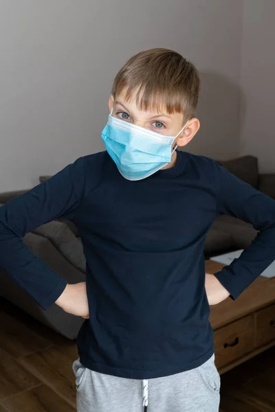 Muchacho triste en cuarentena de coronavirus en casa con máscara médica azul. COVID19 control epidémico del coronavirus. Niño infeliz y deprimido en cuarentena de máscara en casa aislado —  Fotos de Stock