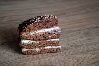 Çikolatalı kek. Tabakta bir parça kek var. Tatlı yemek. Tatlı tatlı. Ahşap arka plan. Tahta bir stantta. Kapatın. Metin yazmak için yer