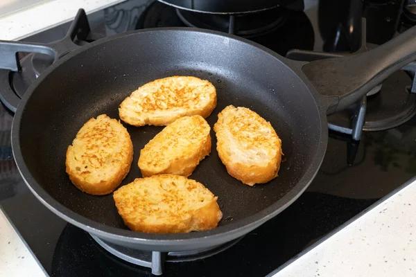 Bread croutons in an egg are fried in a pan. Close-up. Top-side view. — Stock Image Bread Croutons Egg Fried Pan Close Top Side View Stock Photo