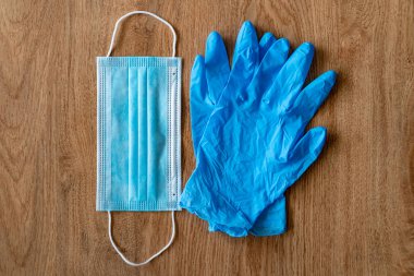 COVID19 koruyucu denekler. Tek kullanımlık plastik eldivenler ve tahta bir arka planda maske. Coronavirus koruması