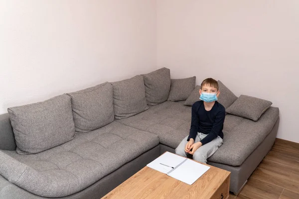 Isolated child Quarantined at Home in mask, Coronavirus Epidemic. Distance education and learning. Self isolation, home quarantine. World Crisis COVID-19. Distance learning at home. Space for text.