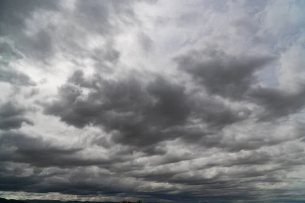 Kara bulutlar patlayan volkandan çıkan büyük siyah bir duman gibi görünüyor. Şiddetli yağmur fırtınasından önce fırtına geliyor. Gökyüzü bulutlarla kaplı..