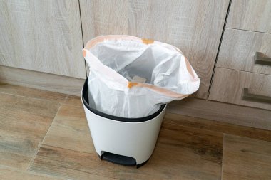 Plastik torbalı çöp tenekesi. Mutfakta çöp kovası var..