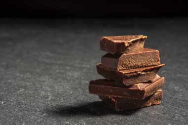 dark chocolate on a stone. Dark background.