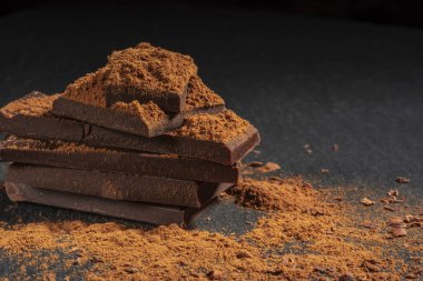 dark chocolate on a stone. Dark background.